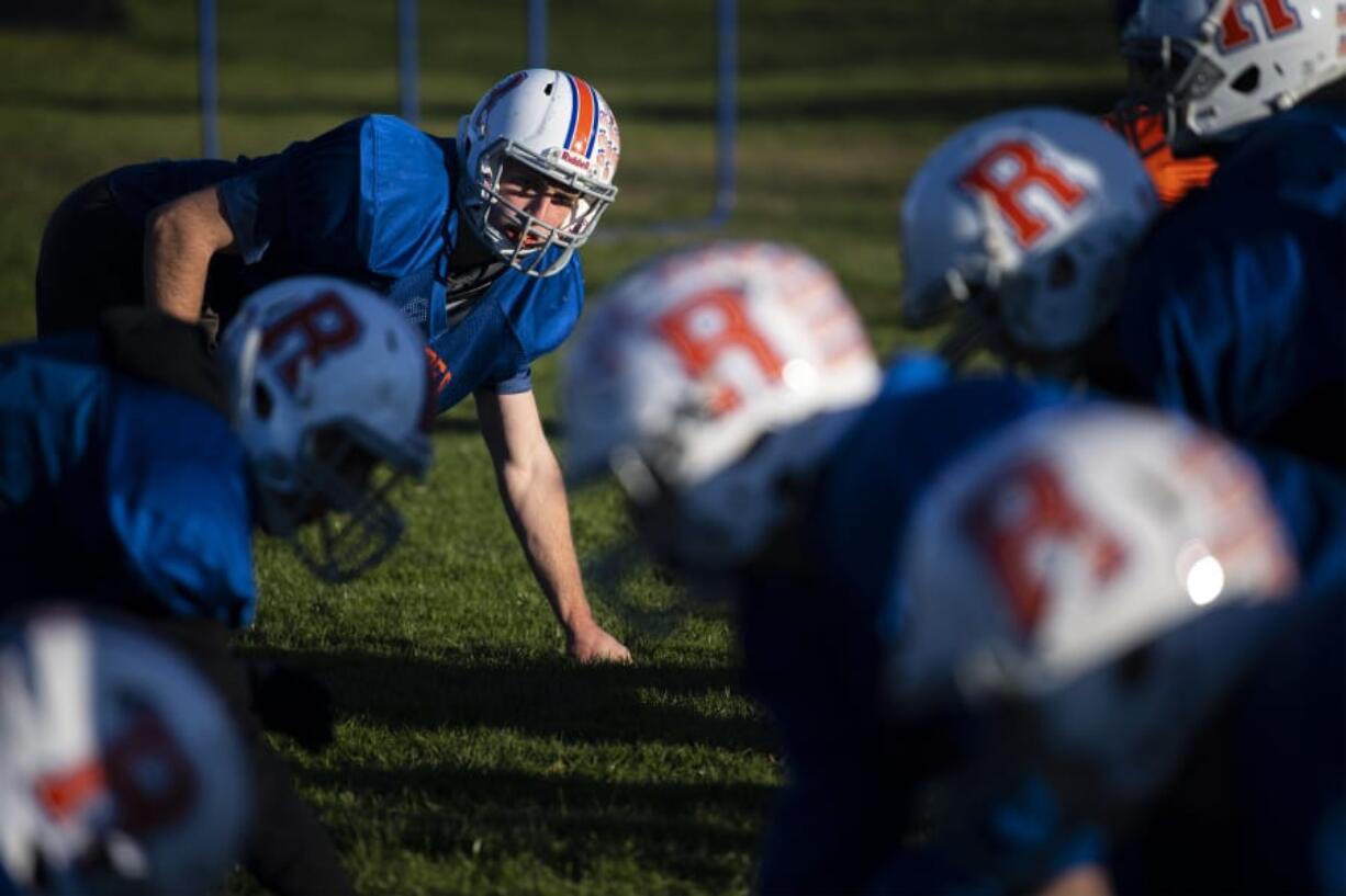 Trey Knight, top left photo, watches the center from the line of scrimmage during a practice at Ridgefield High School. Evergreen quarterback Carter Monda (11) has been one of the area&#039;s most prolific passers. Both players, who excel in other sports, are key pieces to their team&#039;s success after coming out for football for the first time.