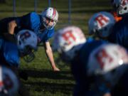 Trey Knight, top left photo, watches the center from the line of scrimmage during a practice at Ridgefield High School. Evergreen quarterback Carter Monda (11) has been one of the area&#039;s most prolific passers. Both players, who excel in other sports, are key pieces to their team&#039;s success after coming out for football for the first time.