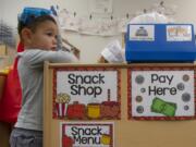 Austin Park, 3, watches a tour as school district patrons visit his class in the Early Learning Center at the Ridgefield Administrative and Civic Center.