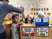 Thomas Duncan encourages his students, from left, Austin Park, 3,  Addison Horn, 3, and Rylie Allen, 3, to keep playing while a tour observes the class in district's new the Early Learning Center. To keep up with rapid growth, the school board plans to ask voters to approve a facilities bond next February.