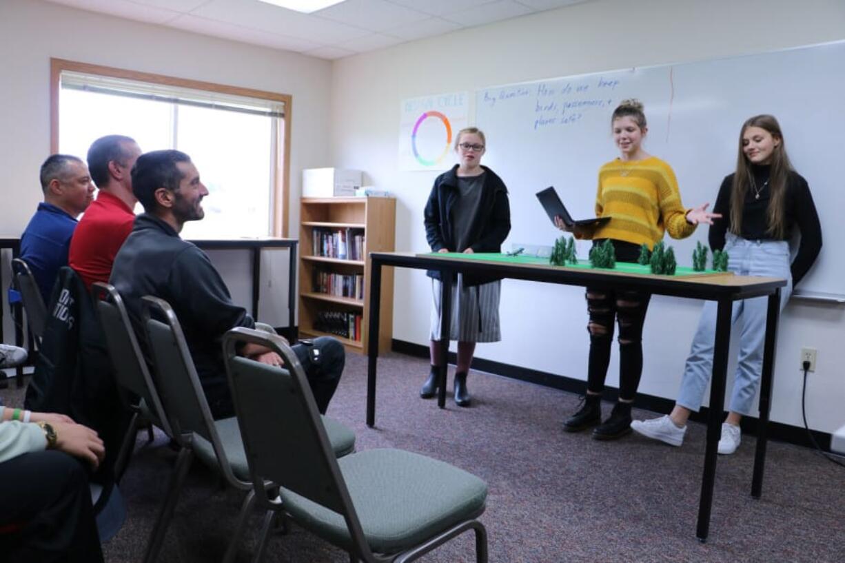 BATTLE GROUND: Horizon Airlines pilot Darin Chung, Portland International Airport Operations Manager Sterling Kesler, and Port of Portland Environmental Specialist Nick Atwell listen as River HomeLink students present possible solutions to the problem of bird strikes.