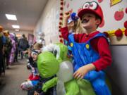 Hathaway Elementary School first-grader Joshue Rivera dresses as Mario and Yoshi during a Halloween parade at the school in Washougal on Oct. 31, 2019.