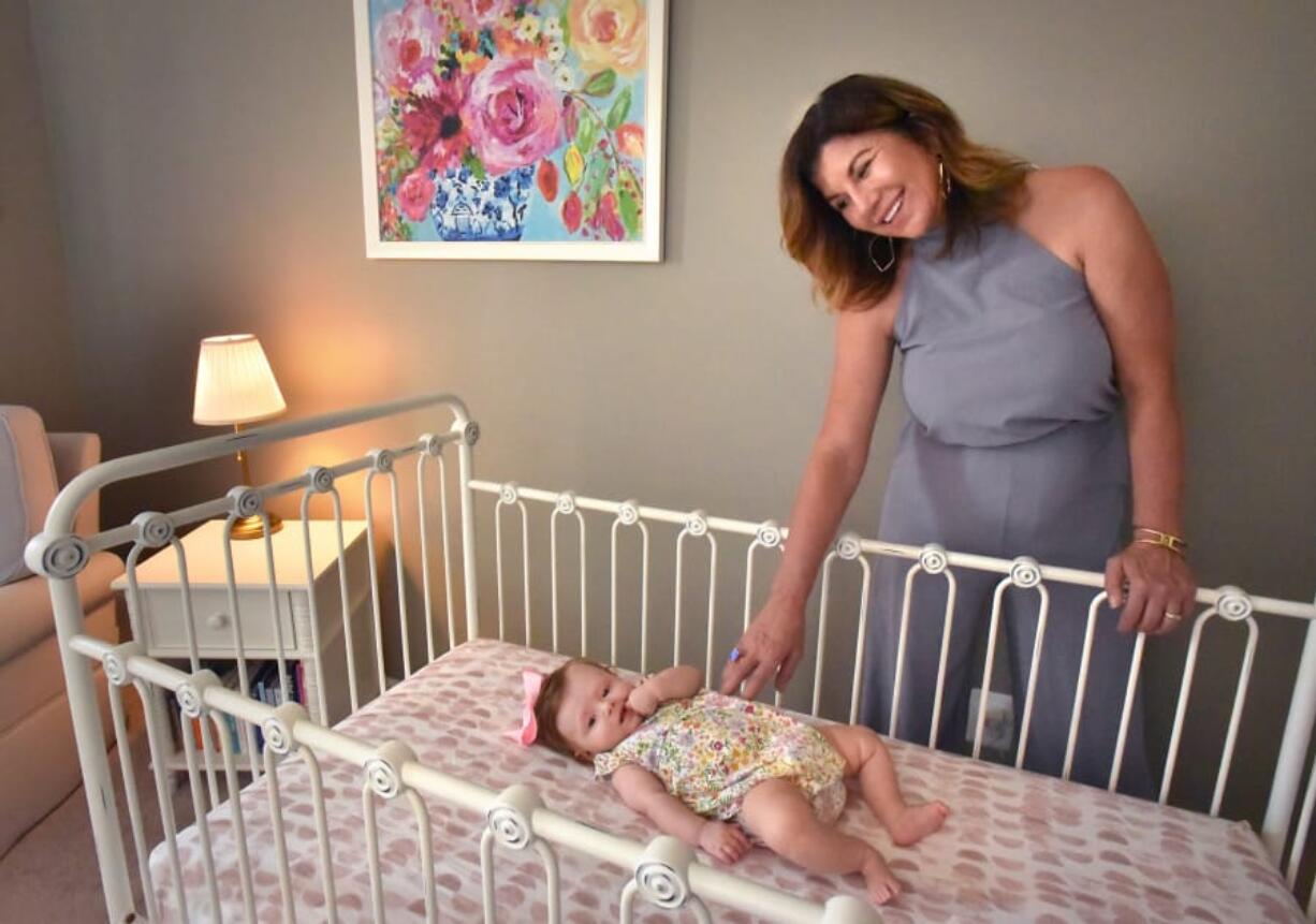 Mary Bauer, president of Bratt Decor, visits the Calhoun family home in Halethorpe, where 5-month-old Rosie Calhoun rests in a Bratt Decor crib. Mary Bauer founded the company with her husband, Stephen Bauer, in 1994, when they couldn&#039;t find stylish and safe nursery furniture for their first child.