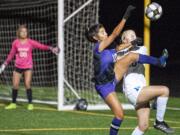 Columbia River’s Yaneisy Rodriguez, front, tries to win a ball against Ridgefield’s Jaynie Murray in the Chieftains’ 2-1 win on Tuesday at Chieftain Stadium.