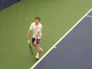 Columbia River's Wilson Keller prepares to serve in his 2A sub-district singles final against teammate Matt Rudi on Saturday, Oct.