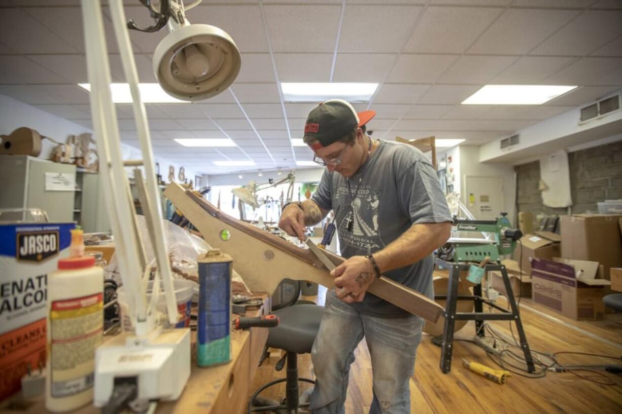 Scott Beaty makes a guitar at the Appalachian School of Luthiery in Hindman, Ky. The school has a program that trains people in drug recovery to make string instruments. (Ryan C.