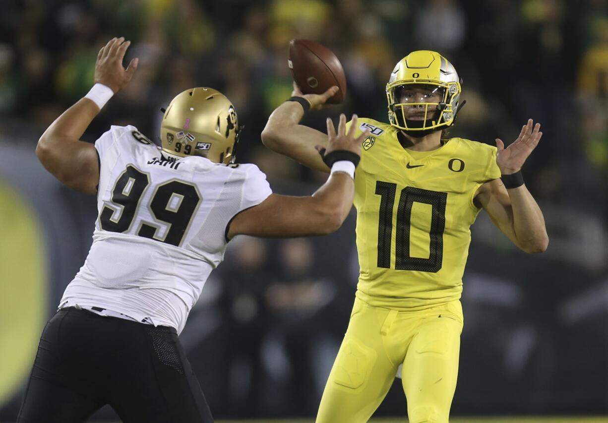 Colorado's Jalen Sami, left, rushes Oregon's Justin Herbert during the first quarter of an NCAA college football game Friday, Oct. 11, 2019, in Eugene, Ore.