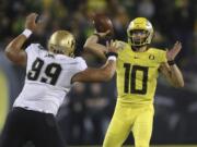 Colorado's Jalen Sami, left, rushes Oregon's Justin Herbert during the first quarter of an NCAA college football game Friday, Oct. 11, 2019, in Eugene, Ore.