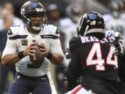 Seattle Seahawks quarterback Russell Wilson (3) works in the pocket as Atlanta Falcons defensive end Vic Beasley (44) pressures during the first half of an NFL football game, Sunday, Oct. 27, 2019, in Atlanta.