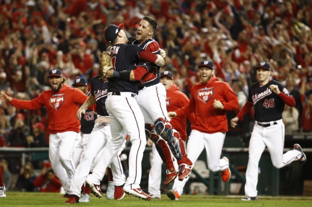 Washington Nationals&#039; Yan Gomes and Daniel Hudson celebrate after Game 4 of the baseball National League Championship Series Tuesday, Oct. 15, 2019, in Washington. The Nationals won 7-4 to win the series 4-0.