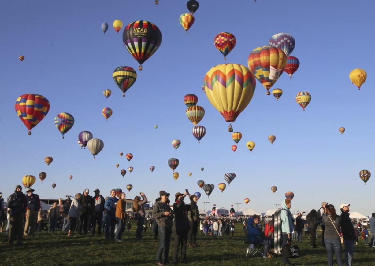 Spectators watch hot air balloons liftoff at the Albuquerque International Balloon Fiesta in Albuquerque, N.M., Sunday, Oct. 6, 2019.