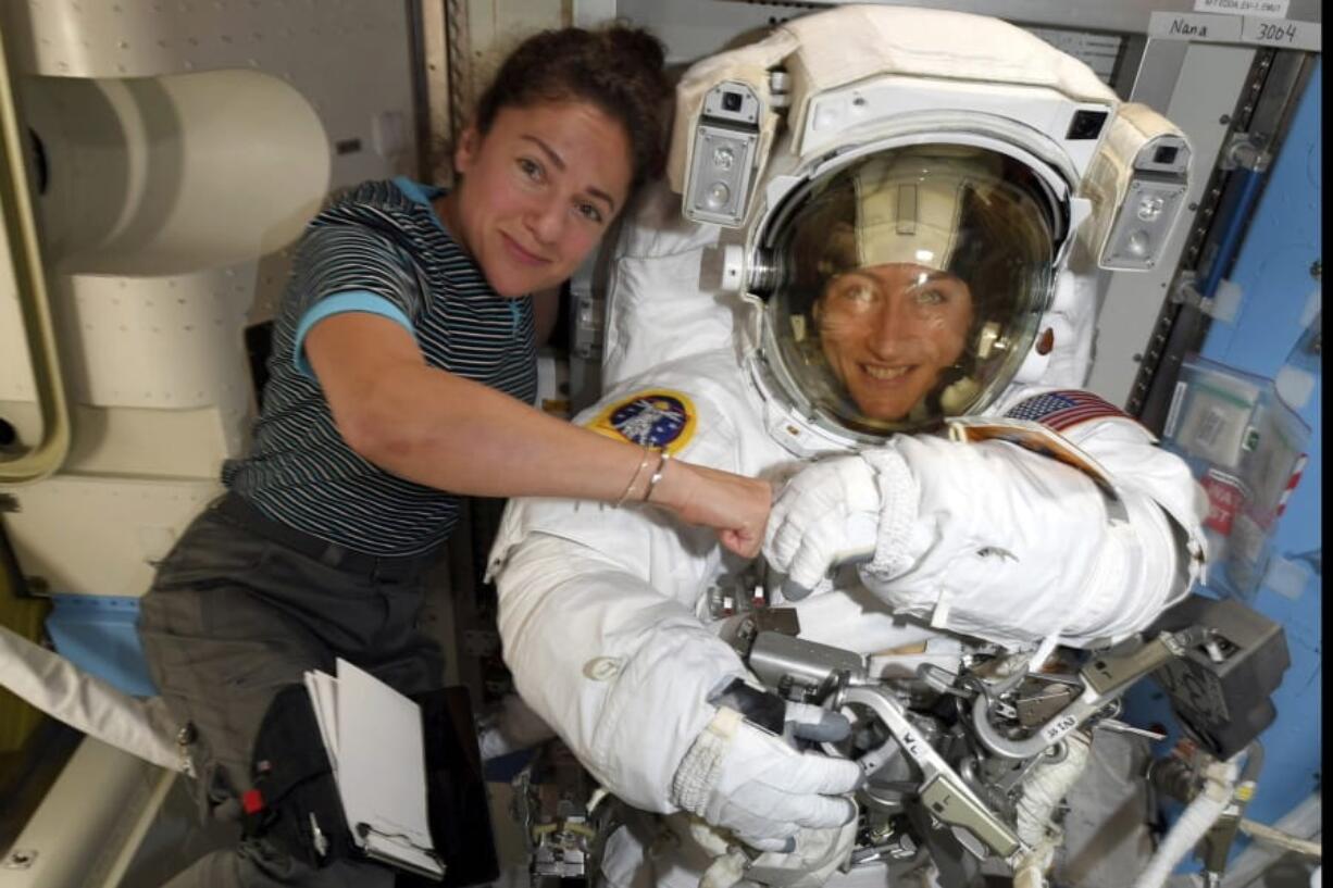 FILE - In this image released Friday, Oct. 4, 2019, by NASA, astronauts Christina Koch, right, and, Jessica Meir pose for a photo on the International Space Station. NASA has moved up the first all-female spacewalk to Thursday, Oct. 17, 2019, or Friday because of a power system failure at the International Space Station.