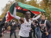 Eliud Kipchoge celebrates with the Kenyan flag after breaking the historic two hour barrier for a marathon in Vienna, Saturday, Oct. 12, 2019. Eliud Kipchoge has become the first athlete to run a marathon in less than two hours, although it will not count as a world record. The Olympic champion and world record holder from Kenya clocked 1 hour, 59 minutes and 40 seconds Saturday at the INEOS 1:59 Challenge, an event set up for the attempt.