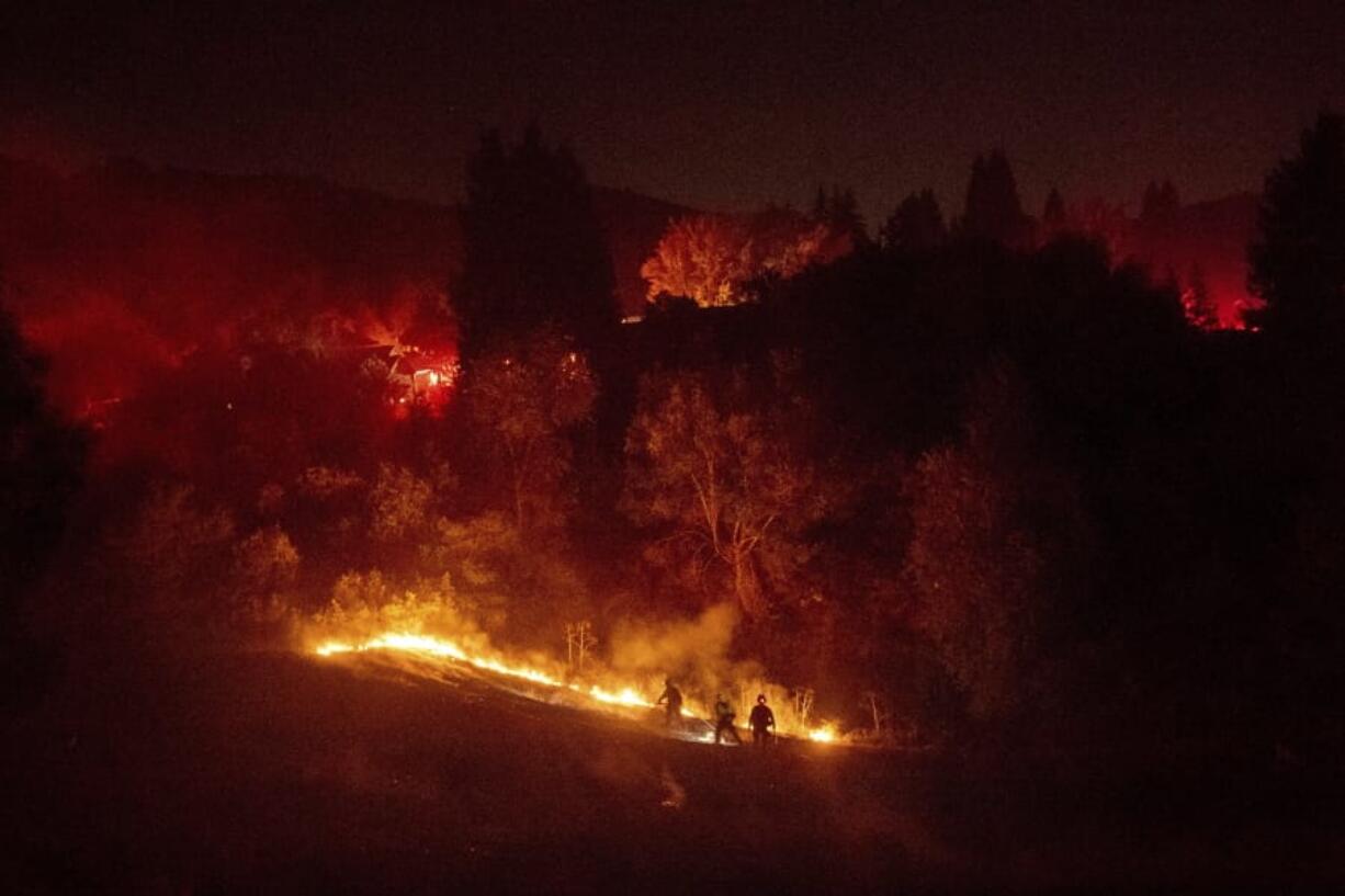 Firefighters work to contain a wildfire burning off Merrill Dr. in Moraga, Calif., on Thursday, Oct. 10, 2019. Police have ordered evacuations as the fast-moving wildfire spread in the hills of the San Francisco Bay Area community. The area is without power after Pacific Gas &amp; Electric preemptively cut service hoping to prevent wildfires during dry, windy conditions throughout Northern California.