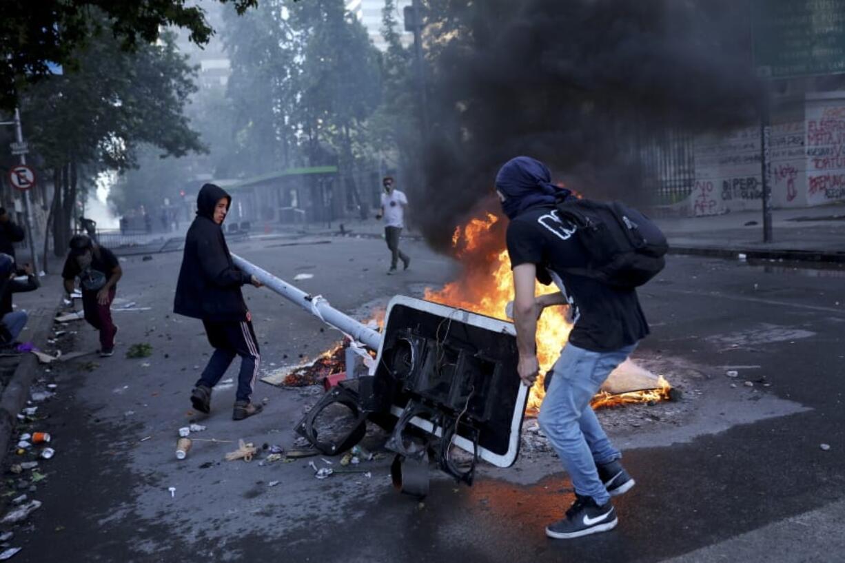 Anti-government protesters set up a barricade Tuesday in Santiago, Chile, during the 12th day of demonstrations.