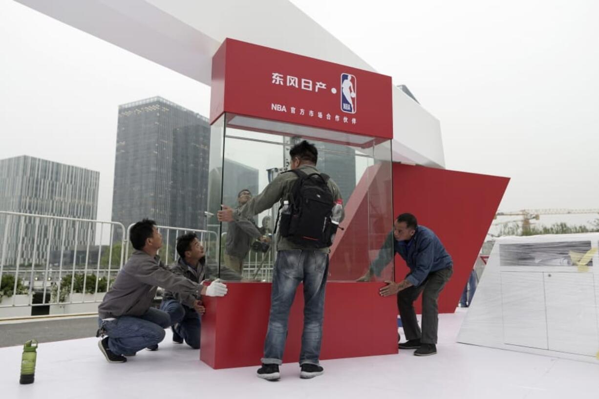 Workers dismantle signage for an NBA fan event scheduled to be held on Wednesday night at the Shanghai Oriental Sports Center in Shanghai, China, Tuesday, Oct. 8, 2019. Chinese state broadcaster CCTV announced Tuesday it will no longer air two NBA preseason games set to be played in the country.