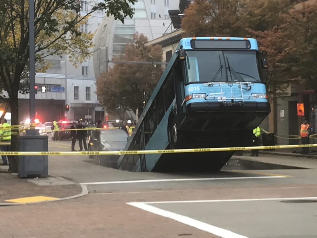 Authorities investigate after a Port Authority bus was caught in a sinkhole in downtown Pittsburgh on Monday, Oct. 28, 2019. The Port Authority of Allegheny County says the lone passenger is being treated Monday morning for minor injuries.