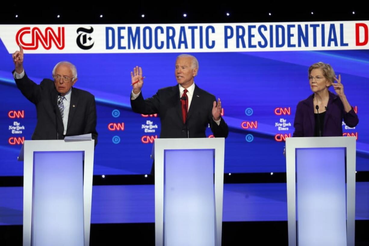 Democratic presidential candidate Sen. Bernie Sanders, I-Vt., left, former Vice President Joe Biden, center, and Sen. Elizabeth Warren, D-Mass., raise their hands to speak during a Democratic presidential primary debate hosted by CNN/New York Times at Otterbein University, Tuesday, Oct. 15, 2019, in Westerville, Ohio.