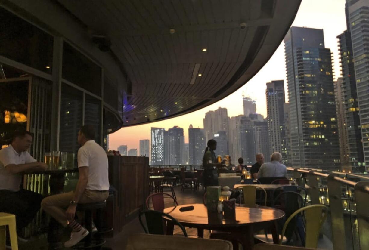 People enjoy drinking alcoholic beverages Oct. 23 at a restaurant overlooking the Marina district in Dubai, United Arab Emirates. Dubai has loosened its liquor laws to allow tourists to purchase alcohol in state-controlled stores.