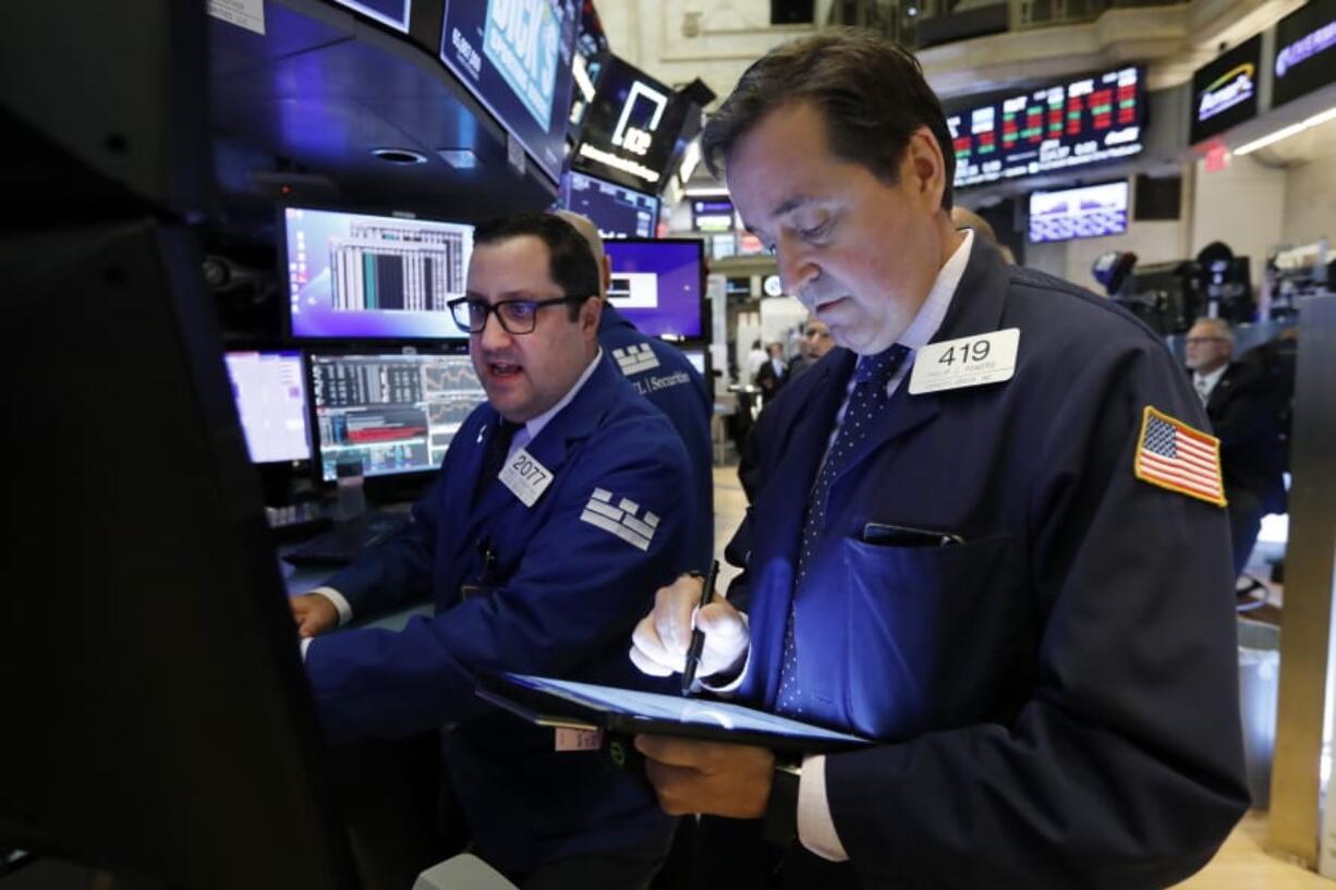 FILE - In this Oct. 8, 2019, file photo specialist Brian Fairbrother, left, and trader Philip Powers work on the floor of the New York Stock Exchange. The U.S. stock market opens at 9:30 a.m. EDT on Thursday, Oct. 17.