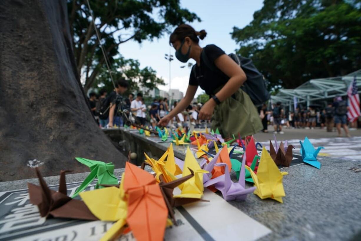 Students fold paper origami cranes as they march to the Chinese University to show support to those students who were arrested by police in Hong Kong, Thursday, Oct.3, 2019.