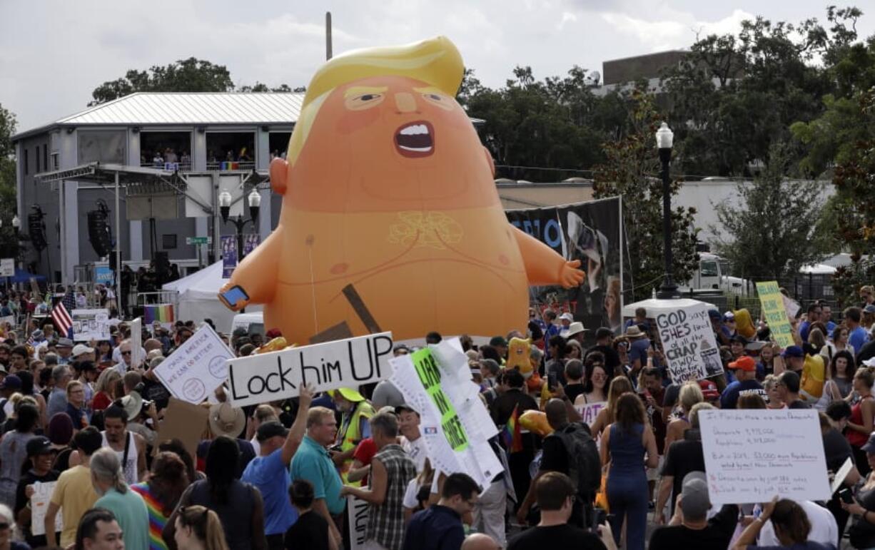 FILE - In this June 18, 2019, file photo, an inflatable Baby Trump balloon towers over protestors during a rally in Orlando, Fla. A coalition of liberal groups is hoping to take the fight over House Democrats&#039; impeachment inquiry of President Donald Trump to the streets.