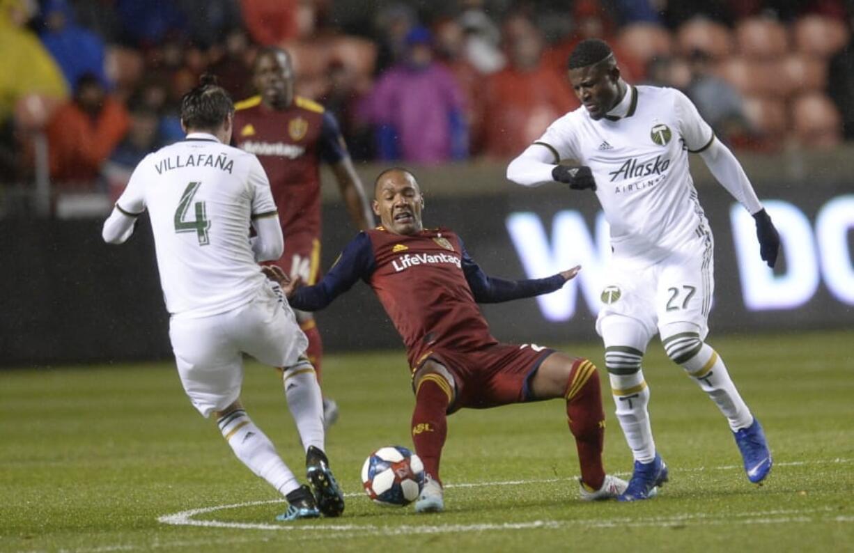 Portland Timbers defender Jorge Villafana (4) pressures Real Salt Lake midfielder Everton Luiz (25) with help from forward Dairon Asprilla (27) aduring the first half of an MLS soccer Western Conference first-round playoff match in Sandy, Utah, Saturday, Oct. 19, 2019.