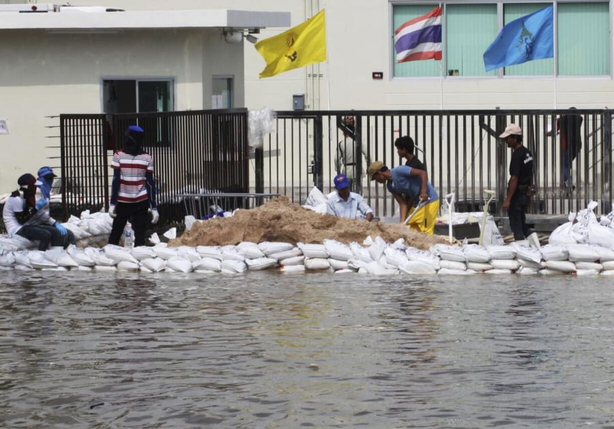 FILE - In this Oct. 9, 2013, file photo, workers build a water barrier with sandbags as floodwater threaten their factory at Amata Nakorn industrial estate in Chonburi province, eastern Thailand. The number of people threatened by climate change-triggered flooding is about three times higher than previously thought, a new study says. But it&#039;s not because of more water. It&#039;s because the land, especially in Asia and the developing world, is several feet lower than what space-based radar has calculated, according to a study in the journal Nature Communications Tuesday, Oct. 29, 2019.