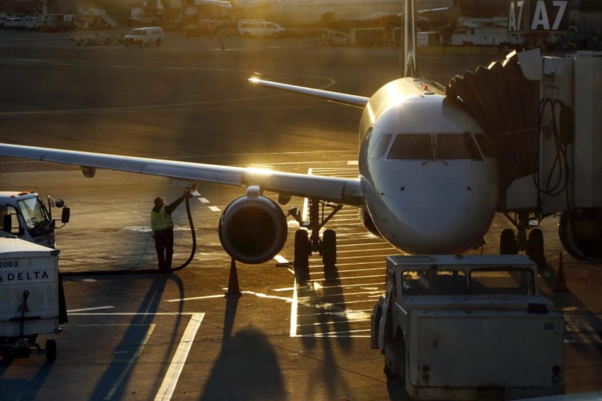 FILE - In this Dec. 8, 2018, file photo a worker fuels a Delta Connection regional airlines passenger jet at Logan International Airport in Boston. More than 7 in 10 U.S. airline passengers (72%) say ticket price is a key deciding factor when choosing an airport to fly into or from, according to a 2019 survey commissioned by NerdWallet and conducted online by The Harris Poll among more than 1,800 U.S. adults who have ever flown on an airplane.