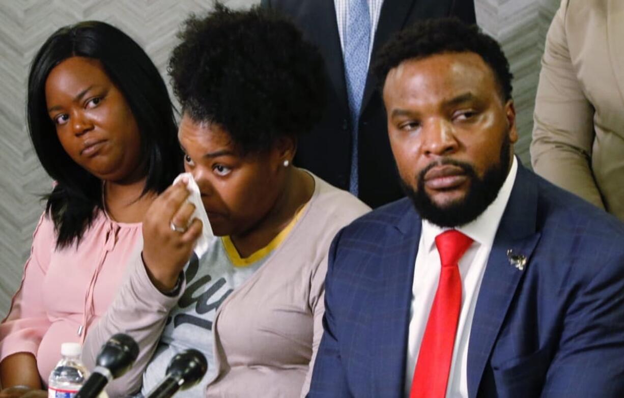 Amber Carr, center, wipes a tear as her sister, Ashley Carr, left, and attorney Lee Merritt, right, listen to Amber and Ashley&#039;s brother Adarius Carr talk about their sister Atatiana Jefferson during a news conference, Monday, Oct. 14, 2019, in downtown Dallas. Jefferson was shot and killed by a white police officer in her Fort Worth home as she played video games with her 8-year-old nephew.