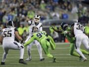 Los Angeles Rams quarterback Jared Goff, center, passes under pressure from Seattle Seahawks defensive end Ziggy Ansah (94) during the first half of an NFL football game Thursday, Oct. 3, 2019, in Seattle.