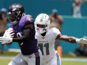 FILE - In this Sept. 8, 2019, file photo, Baltimore Ravens free safety Earl Thomas (29) intercepts a pass, as Miami Dolphins wide receiver DeVante Parker (11), attempts to tackle, during the first half at an NFL football game, in Miami Gardens, Fla. Over the course of nine NFL seasons with the Seattle Seahawks, Earl Thomas picked off 28 passes, earned a Super Bowl ring and was selected to the Pro Bowl six times.