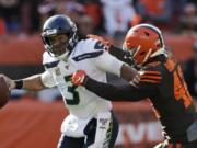 Seattle Seahawks quarterback Russell Wilson (3) avoids Cleveland Browns strong safety Morgan Burnett (42) during the second half of an NFL football game, Sunday, Oct. 13, 2019, in Cleveland.