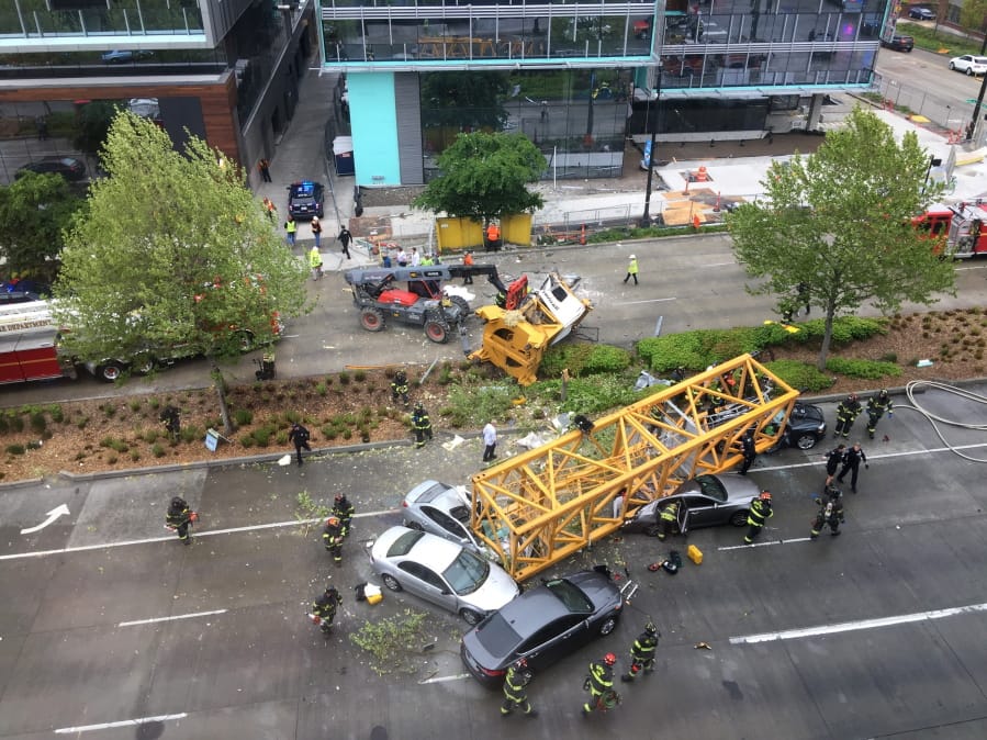 FILE - In this April 27, 2019, file photo, fire and police crew members work to clear the scene where a construction crane fell from a building on Google&#039;s new Seattle campus, crashing down onto one of the city&#039;s busiest streets and killing four people. Washington state&#039;s Department of Labor and Industries released the results of its investigation into the collapse Thursday, Oct. 17, 2019. It found, as experts have long suspected, that the crane toppled because workers who were disassembling it had prematurely removed pins securing the sections of the crane&#039;s mast.