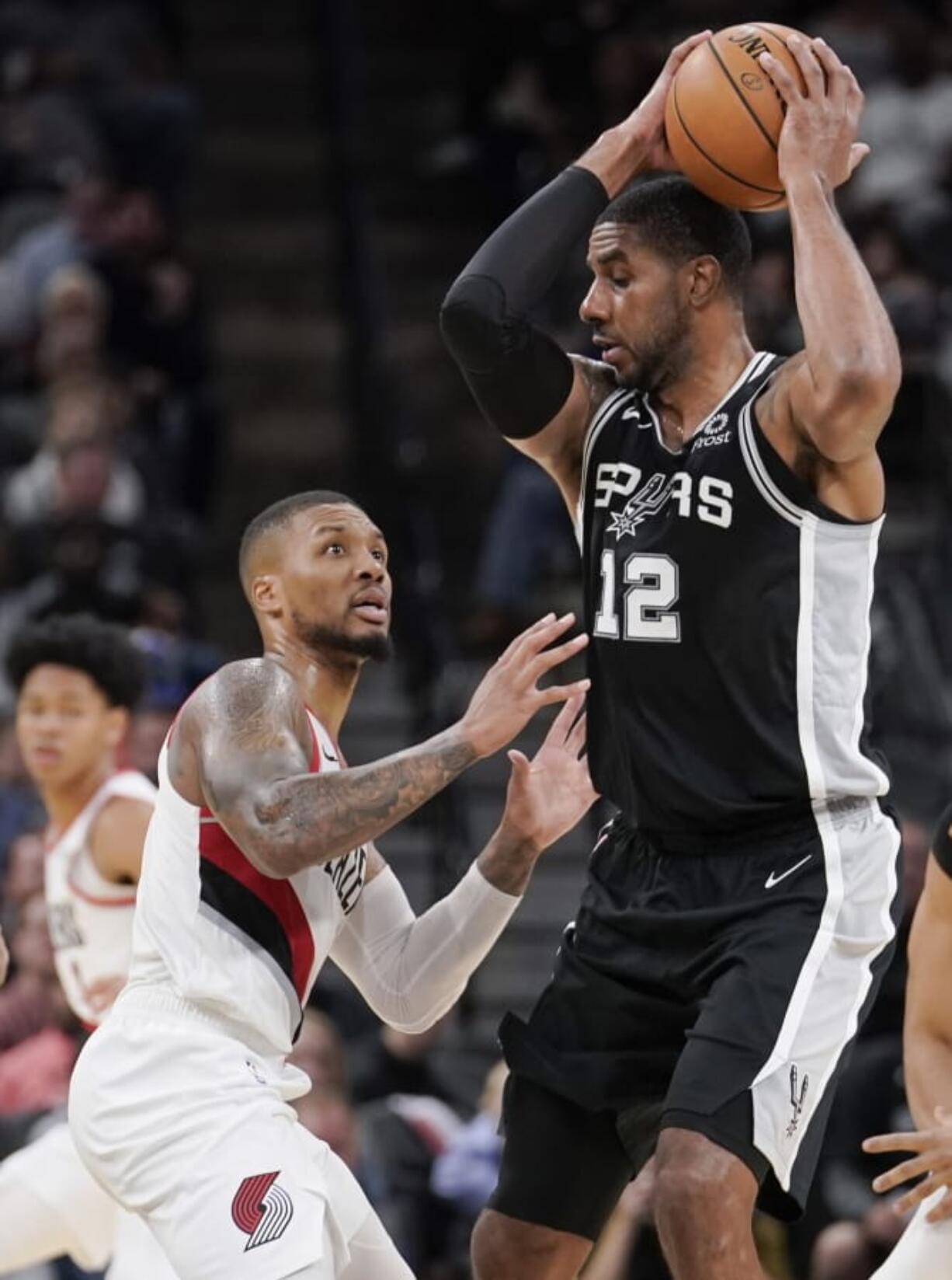 San Antonio Spurs&#039; LaMarcus Aldridge (12) drives against Portland Trail Blazers&#039; Damian Lillard during the second half of an NBA basketball game, Monday, Oct. 28, 2019, in San Antonio. San Antonio won 113-110.