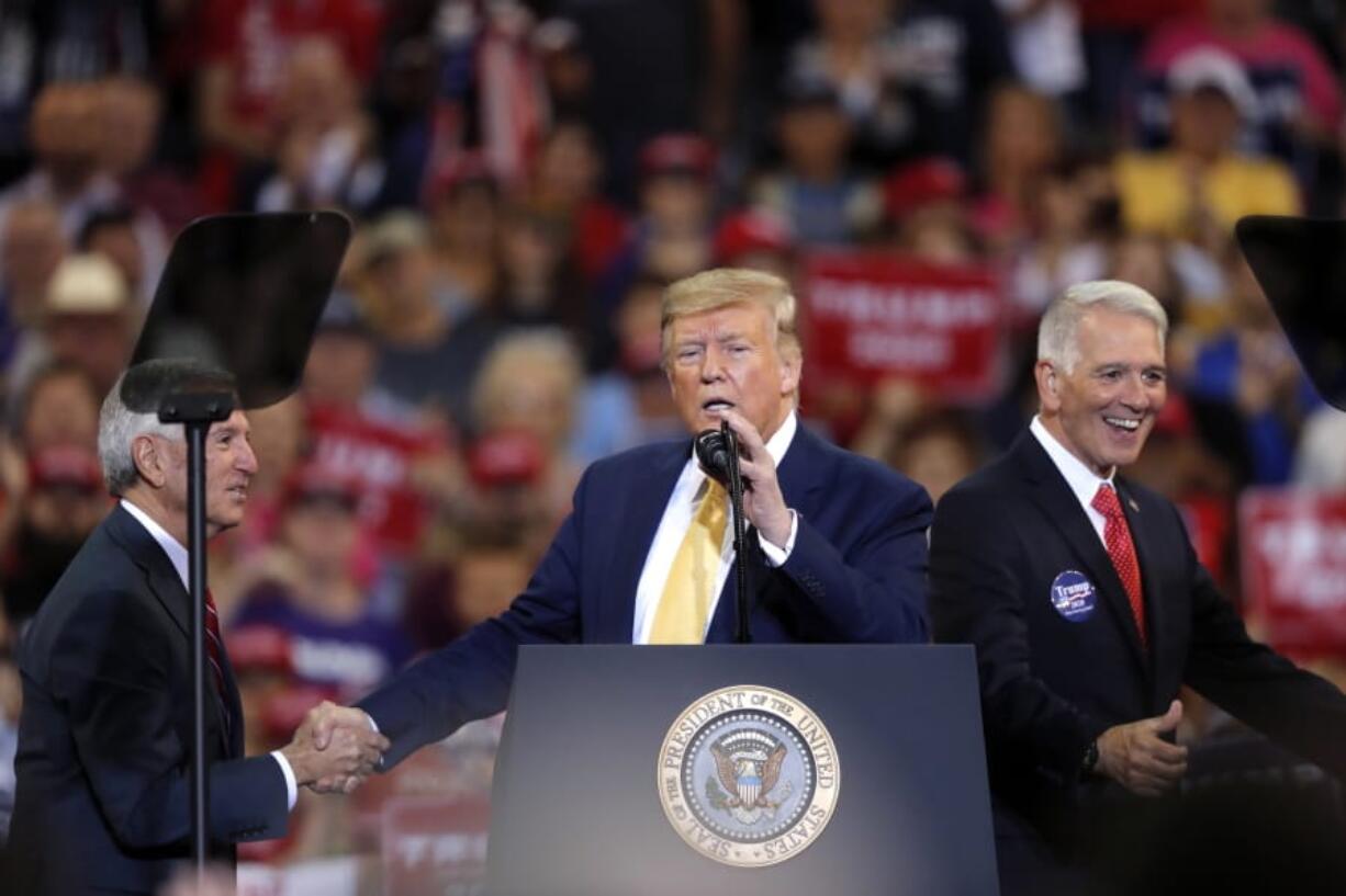 President Donald Trump greets Louisiana Republican gubernatorial candidates Ralph Abraham right, and Eddie Rispone at Trump&#039;s campaign rally in Lake Charles, La., Friday, Oct. 11, 2019. Trump introduced both on the eve of the Louisiana election, urging the crowd to vote for either to unseat incumbent Democrat Gov. John Bel Edwards.