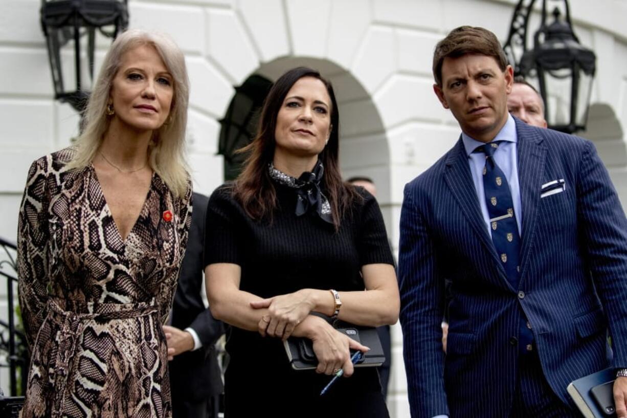 From left, counselor to the President Kellyanne Conway, White House press secretary Stephanie Grisham, and Deputy White House press secretary Hogan Gidley, listen as President Donald Trump speaks to the media on the South Lawn of the White House in Washington, Thursday, Oct. 3, 2019, before boarding Marine One for a short trip to Andrews Air Force Base, Md., and then on to Florida.