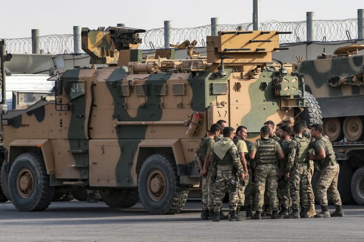 Turkish soldiers prepare to enter Syria aboard an armoured personnel carrier at the border with Syria in Karkamis, Gaziantep province, southeastern Turkey, Tuesday, Oct. 15, 2019. Turkey defied growing condemnation from its NATO allies to press ahead with its invasion of northern Syria on Tuesday, shelling suspected Kurdish positions near the border amid reports that Syrian Kurds had retaken a key town.