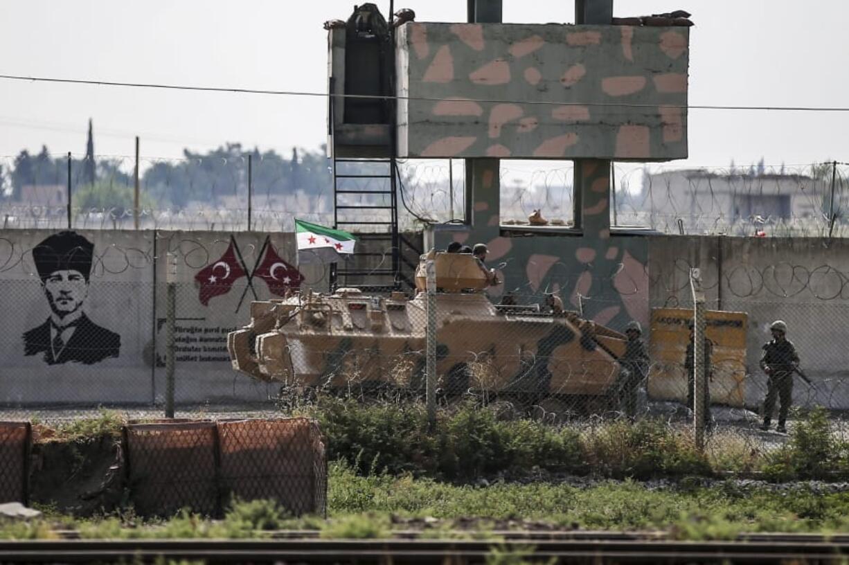 Turkish-backed Syrian opposition fighters on an armoured personnel carrier drive to cross the border into Syria, in Akcakale, Sanliurfa province, southeastern Turkey, Friday, Oct. 18, 2019. Fighting continued in a northeast Syrian border town at the center of the fight between Turkey and Kurdish forces early Friday, despite a U.S.-brokered cease-fire that went into effect overnight.