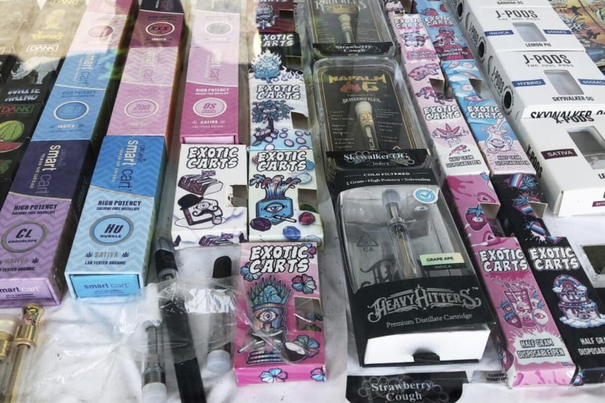 FILE - This Aug. 28, 2019 file photo shows counterfeit packaging for popular vape brands in a display case of a store in downtown Los Angeles. On Thursday, Oct. 3, 2019, the U.S. Centers for Disease Control and Prevention said 1,080 confirmed and probable cases have been reported in 48 states and one U.S. territory. The count includes 18 deaths in 15 states. (AP Photo/Michael R.