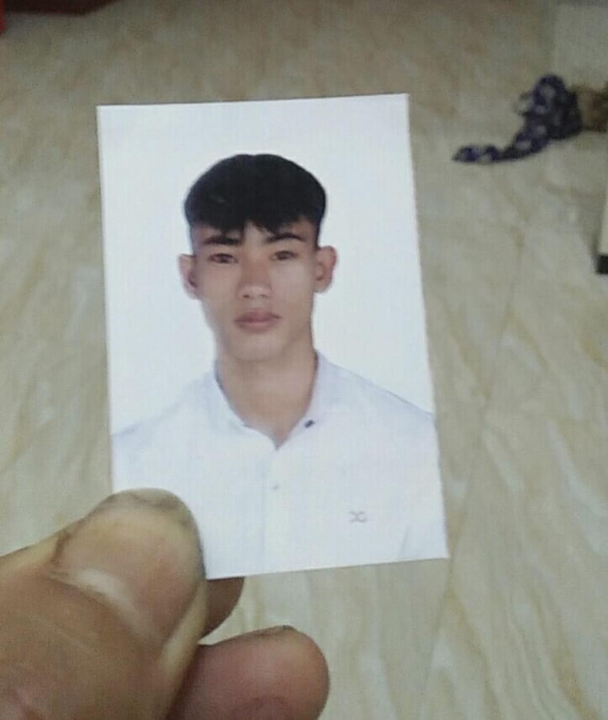 Nguyen Dinh Hai holds an ID photo of his younger brother Nguyen Dinh Luong, 20, at his home on Oct. 26, 2019, in Can Loc district, Ha Tinh province, Vietnam. Luong&#039;s family fears that he may be among the 39 people found dead in the back of a container truck in southeastern England.