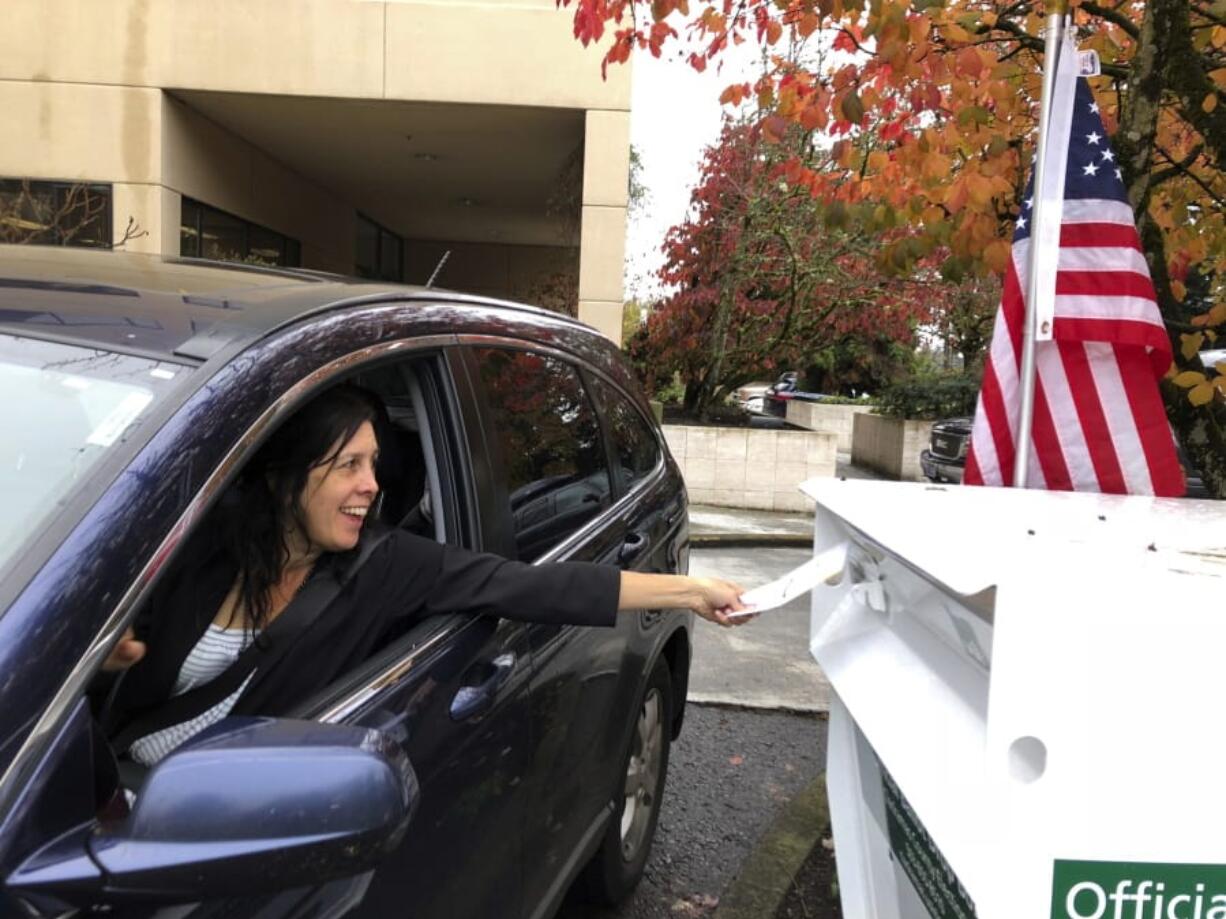 A voter in Lake Oswego, Ore., places her ballot in a designated drop box on Nov. 6, 2018, outside City Hall.