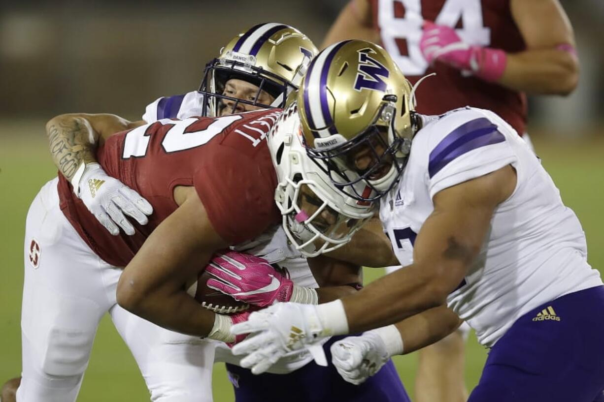 Stanford&#039;s Cameron Scarlett, center, is tackled by Washington&#039;s Elijah Molden, left, and Brandon Wellington during the first half of an NCAA college football game Saturday, Oct. 5, 2019, in Stanford, Calif.