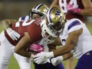 Stanford&#039;s Cameron Scarlett, center, is tackled by Washington&#039;s Elijah Molden, left, and Brandon Wellington during the first half of an NCAA college football game Saturday, Oct. 5, 2019, in Stanford, Calif.