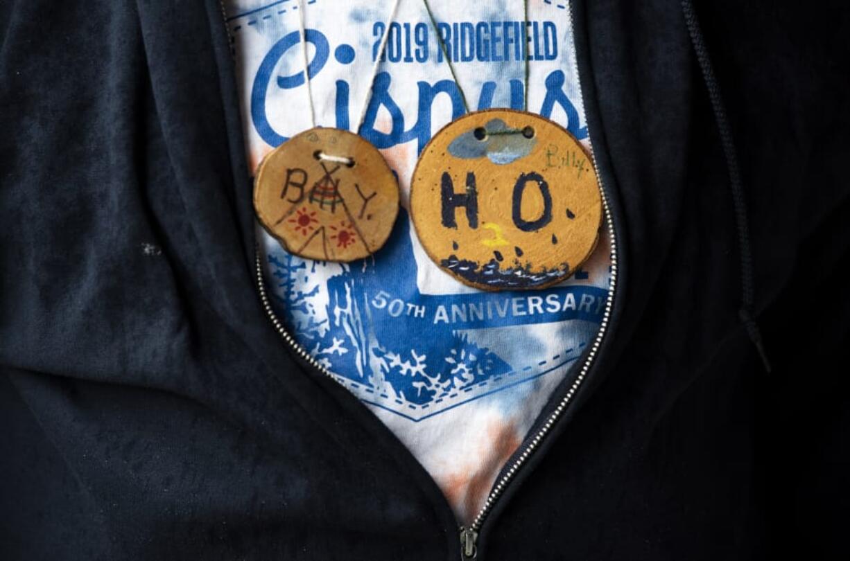 Billy Yaddof of Ridgefield wears two wood cookie name tags during the weeklong outdoor program at the Cispus Learning Center in Randle. Yaddof participated in the camp when he was a fifth grader, and the wood cookie on the left is his name tag from when he was a student. He now makes the wood cookies for the current students attending the camp.