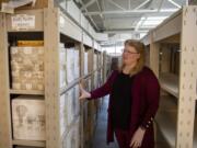 Braille program specialist and coordinator Kandi Lukowski describes the number of volumes it takes to make up one textbook at the Washington State School for the Blind&#039;s Ogden Resource Center. The precalculus book sitting on the top of the boxes is transcribed into six boxes of Braille volumes beneath it. Some textbooks can take more than a year to transcribe.