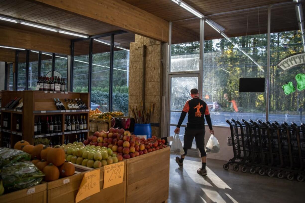 Adam Nelson of Camas heads out the door at Camas Produce, where a driver drove through the front of the store nearly 10 months ago. &quot;It&#039;s nice to have it back,&quot; he said.