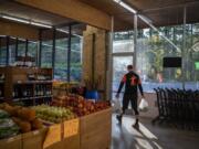 Adam Nelson of Camas heads out the door at Camas Produce, where a driver drove through the front of the store nearly 10 months ago. &quot;It&#039;s nice to have it back,&quot; he said.