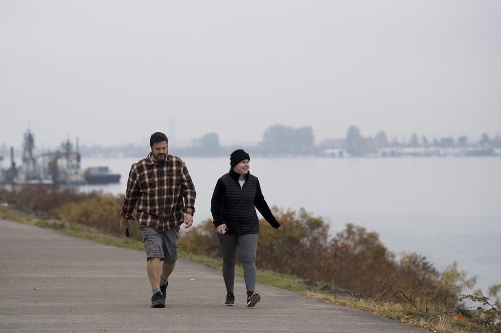 Vancouver residents Justin and Kelly Venetucci take in a foggy view of the Columbia River while enjoying a brisk, fall walk together Monday morning, Nov. 4, 2019. The couple said they try to walk together almost everyday although they wouldn't mind if blue skies made an appearance again. "I like the sunny fall," Kelly Venetucci said.