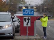 Jan Trygg of Vancouver drops off her ballot on foot at the downtown drop-off box on Tuesday morning.